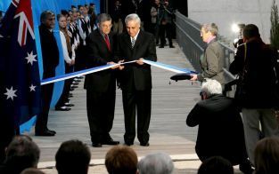 JERUZALEM â€“ De IsraÃ«lische president Moshe Katzav (midden, rechts) en de directeur van het Yad Vashem holocaustmuseum in Jeruzalem, Avner Shalev (midden, links), knipten dinsdag samen het lint door tijdens de heropening van het grootste holocaustmuseum