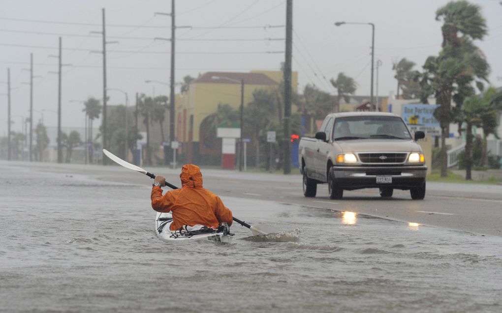 Een man peddelt over de boulevard van South Padre Island, Texas. Foto EPA