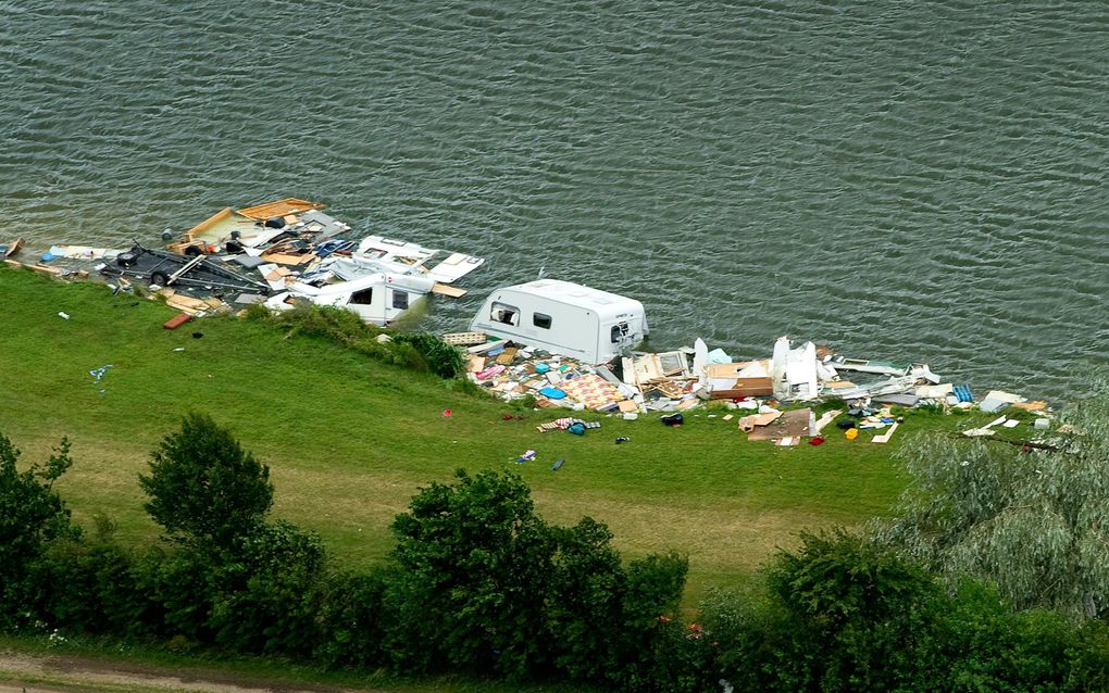 Bij een camping in het Achterhoekse Vethuizen is maandagmorgen begonnen met de berging van tien caravans die afgelopen week in de Kemperplas waren beland door het noodweer. Foto ANP