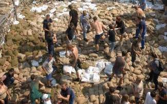 Honderden vrijwilligers werpen dammen op van zandzakken bij het Oost-Duitse Coswig, waar de Elbe nog stijgt. Op de voorgrond een bordje met de aanduiding Elbe. - Foto’s EPA