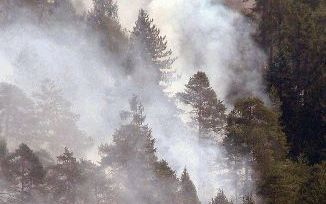 CARALTE - Een blushelikopter stort een lading water op een bosbrand in een bos bij Caralte in de Italiaanse Dolomieten. Door de extreme droogte zijn in het gebied tientallen branden ontstaan. - Foto EPA