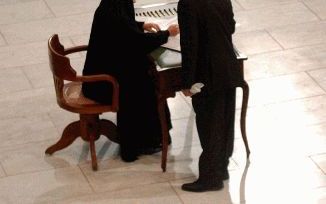 BAGDAD â€“ Een van de vrouwen van de 25 koppen tellende Iraakse regeringsraad tekende maandag tijdens een plechtige ceremonie in Bagdad de nieuwe interim-grondwet. - Foto EPA