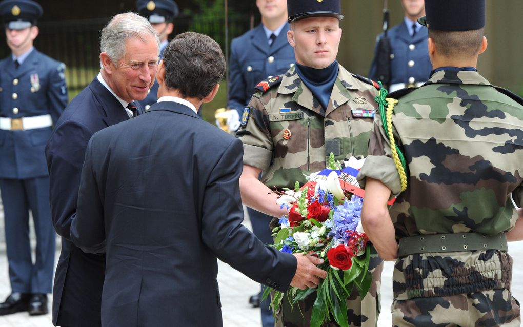 De Franse president Nicolas Sarkozy (r.) en de Britse prins Charles leggen een krans bij het standbeeld van koning George VI in Londen. Foto EPA