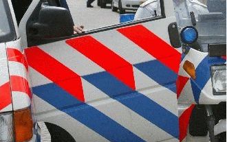 DRACHTEN - Politieagenten bewaken de toegang tot het regionale CNV-kantoor in Drachten. Boeren die door de staking in de zuivelsector met hun melk bleven zitten, kwamen daar dinsdag verhaal halen. - Foto ANP