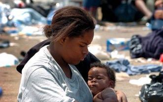 NEW ORLEANS - Een moeder met haar kind wacht als een van de laatsten op evacuatie uit New Orleans. Foto EPA.