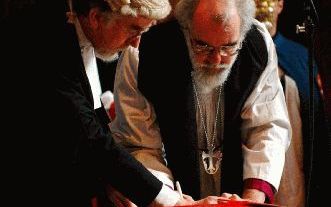 LONDEN - Dr. Rowan Williams zette maandag in het Lambeth Palace in Londen zijn handtekening onder het document waarmee hij het ambt van aartsbisschop van Canterbury aanvaardt. Hij deed dat onder het toeziend oog van Jong Rees (l.), de ambtelijk secretaris