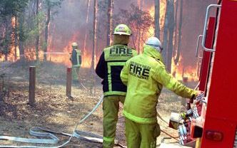 SYDNEY - De Australische brandweer in actie tijdens een bosbrand woensdag in een buitenwijk van Sydney. Rond de 5000 brandweerlieden proberen de meer dan zeventig brandhaarden in het oosten van AustraliÃ« te blussen. - Foto EPA