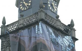 GOUDA â€“ Abseilers hangen een groot fotodoek aan de toren van de Sint Janskerk in Gouda. Het doek moet mensen interesseren voor de Goudse Glazen, de wereldberoemde gebrandschilderde ramen van de kerk. Foto Martin Droog