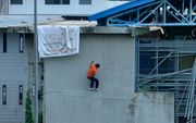 Een gevangene ontsnapt uit de gevangenis van Guayaquil in Ecuador, nadat hij eerst een spandoek heeft opgehangen. beeld EPA, Marcos Pin