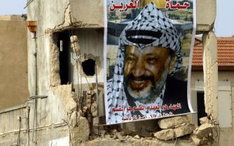 RAMALLAH â€“ In verband met de dood van de Palestijnse leider Yasser Arafat hangen de vlaggen boven zijn hoofdkwartier in Ramallah halfstok. Foto EPA