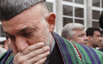 KABUL - De zittende president Hamid Karzai verlaat een stemlokaal. Foto EPA