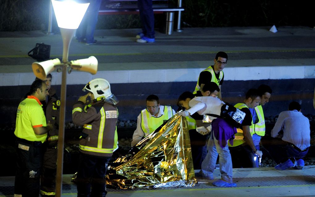 Politie en reddingwerkers donderdagochtend op het station van Castelldefels in Spanje. Foto ANP