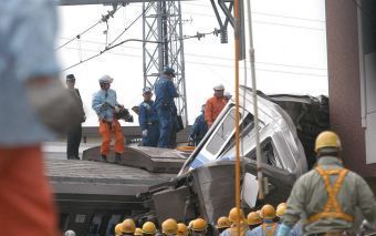 AMAGASAKI â€“ Japanse reddingswerkers probeerden dinsdag gewonde passagiers uit de verongelukte trein te bevrijden. Foto EPA