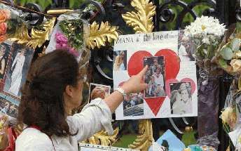 LONDEN - Een vrouw en twee kinderen kijken bij Kensington Palace in Londen naar een van de vele eerbetonen aan het adres van de overleden prinses van Wales, Lady Diana. Zondag is het precies vijf jaar geleden dat de voormalige echtgenote van de Britse kro