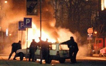 BELGRADO - Servische politie kijkt toe als auto\'s van de VN in brand staan (zie volgende foto). Bij onrustin Belgrado tussen ServiÃ«rs en Albanezen zijn enkele tientallen mensen gewoond geraakt. Foto EPA