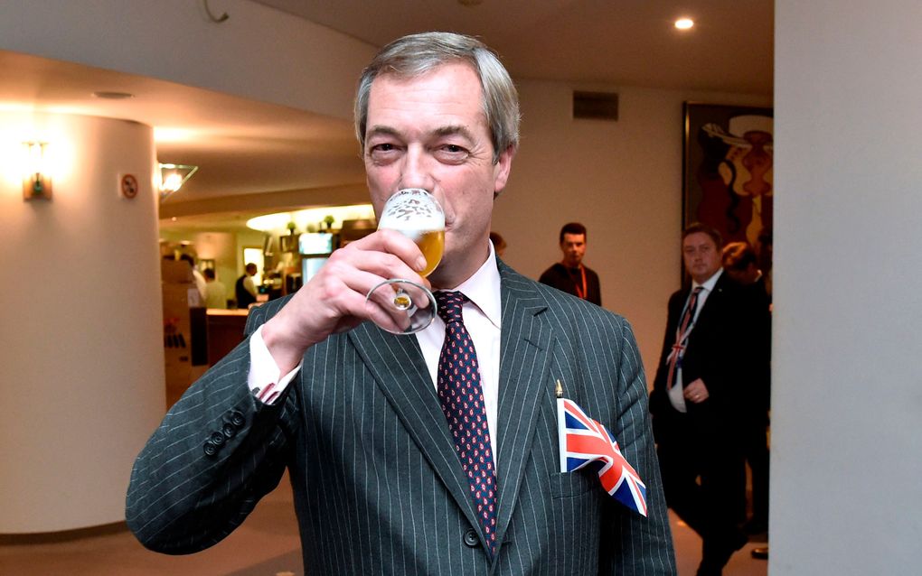 Nigel Farage, leider van de Brexit Party, drinkt een biertje in de gangen van het Europees Parlement. beeld AFP