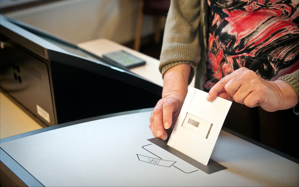 WOLFHEZE - Een blinde vrouw stopt haar stembiljet in de stembus. Het biljet is even tevoren geprint door een stemcomputer. Foto ANP