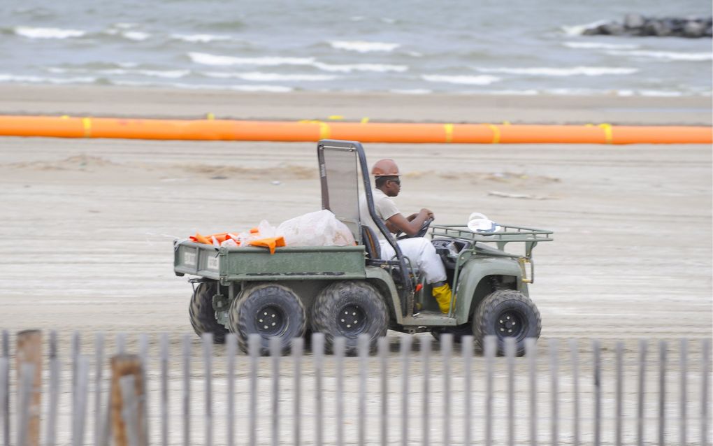 MIAMI - Een lid van het schoonmaakteam van olieconcern BP speurt naar olie op het strand van Grand Isle. Foto EPA