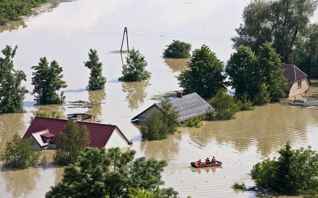 Reddingwerkers in het ondergelopen dorp Janowiec, Polen. Foto EPA