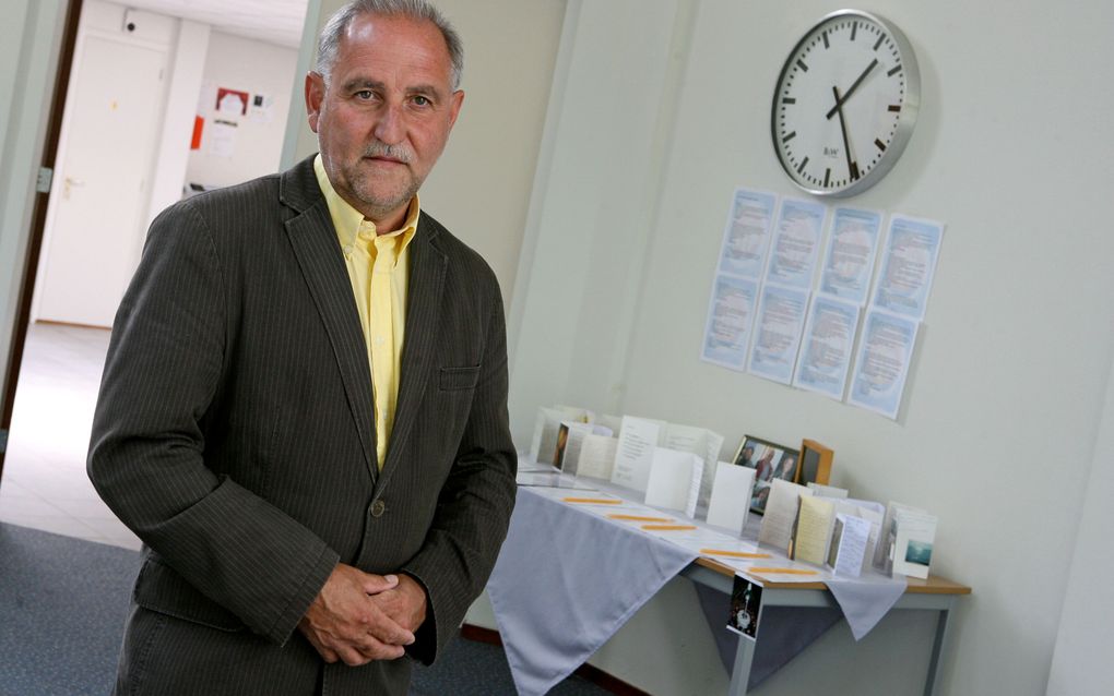 Ds. J. M. Weststrate, predikant van de vrije evangelische gemeente in Heerde, in de kerk bij een tafel met onder meer foto’s van de omgekomen familie Donkervoort. Foto RD, Anton Dommerholt