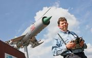 Henk van Harten bestuurt met zijn geavanceerde afstandsbediening de levensechte MiG over drie assen. Het vliegtuig lijkt vanaf een zuil op zijn terrein het luchtruim te kiezen. „De straaljager is nog helemaal originele staat.” Foto RD, Anton Dommerholt