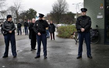 Prins Willem-Alexander sprak dinsdag in het Haagse Laakkwartier met politieagenten, hulpverleners en bewoners van de Antheunisstraat. Foto ANP