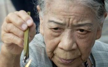 NAGASAKI - Een vrouw herdenkt de slachtoffers van de atoombom, die zestig jaar geleden op de Japanse stad Nagasaki viel. Foto EPA