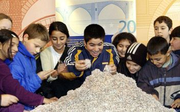 BERLIJN â€“ Schoolkinderen spelen op een eurotentoonstelling in Berlijn met een berg versnipperde Duitse marken. - Foto EPA