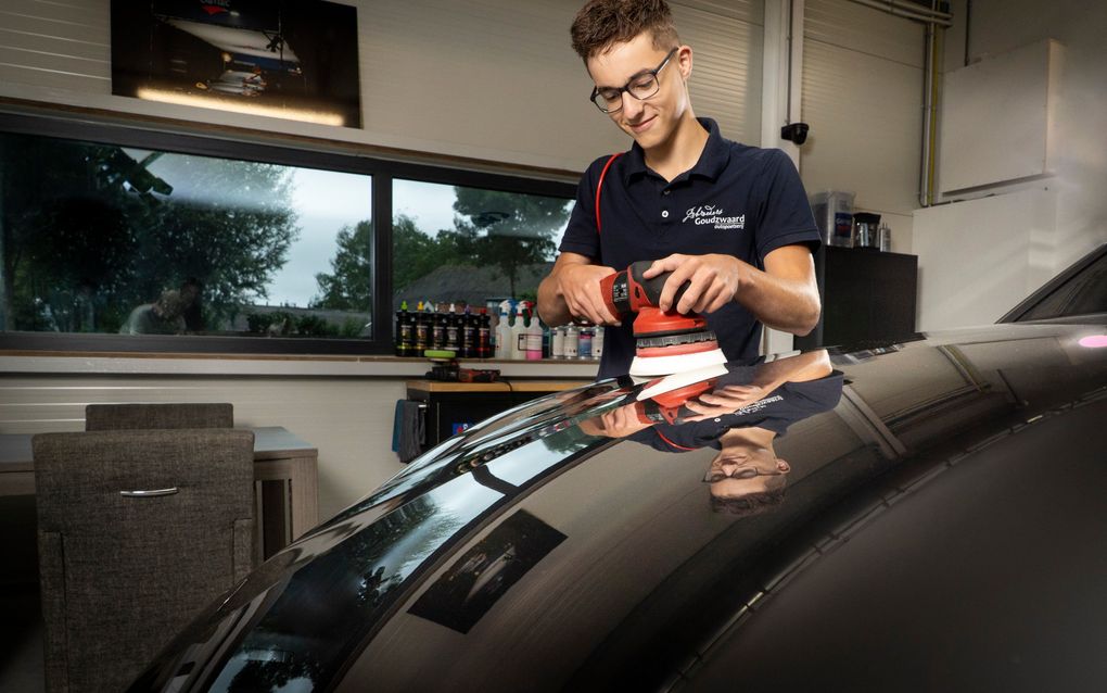 In het poetsbedrijf van zijn broers verwijdert Hermen met een speciale machine de krassen uit de auto’s. beeld Niek Stam