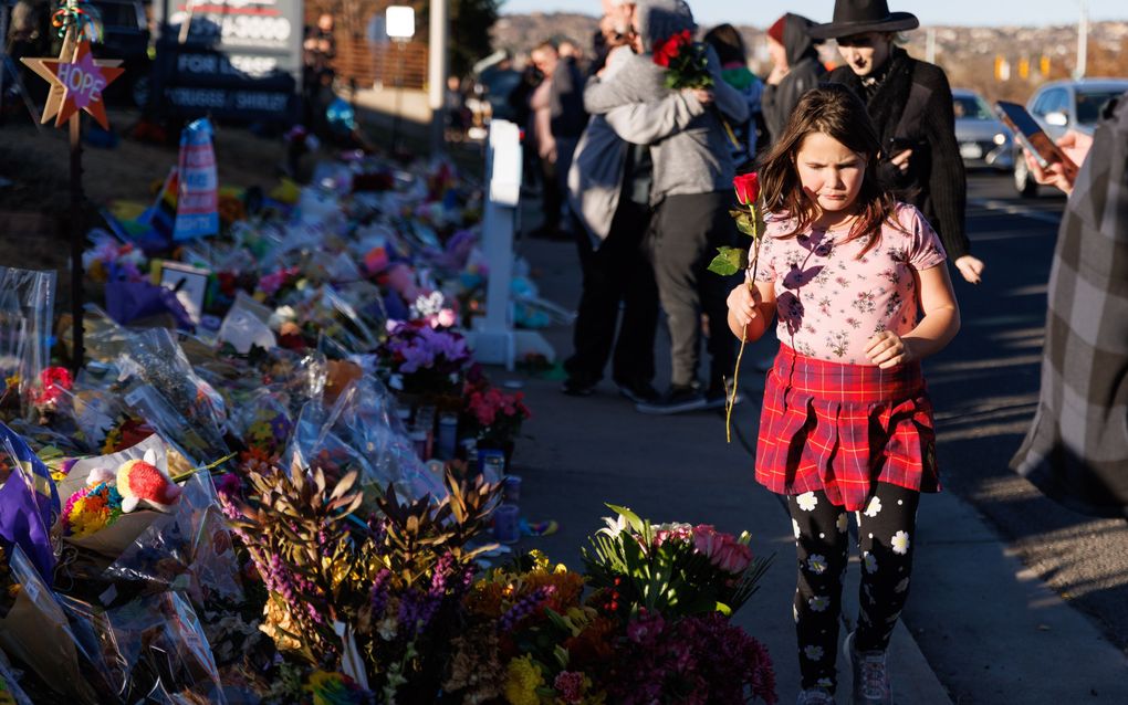 Mensen laten bloemen achter bij een gedenkteken voor de slachtoffers van een schietpartij in de LGBTQ-nachtclub Club Q in Colorado Springs. beeld EPA, Liz Copan 