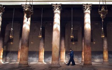 BETHLEHEM â€“ Een Palestijnse politieman surveilleert bij de Geboortekerk in Bethlehem. Het stadje onder Palestijns bestuur hoopt rond Kerst meer toeristen te ontvangen dan de afgelopen drie jaar. Foto EPA