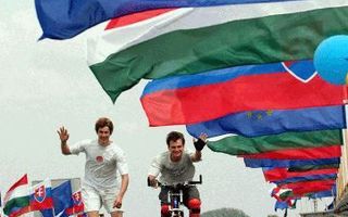 RAJKA â€“ Een Slowaakse fietser en een skater steken in de buurt van de grens met Hongarije en Oostenrijk een brug over die versierd is met EU vlaggen. Zowel Slowakije als Hongarije werd afgelopen zaterdag lid van de Europese Unie. Foto EPA
