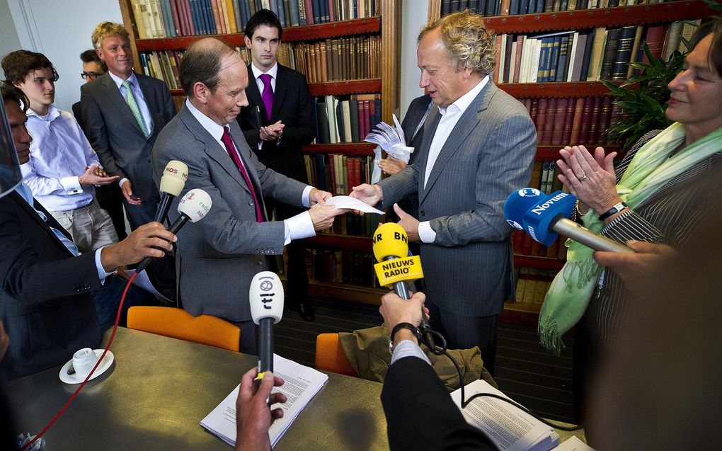 Andre Kolodziejak (L), econoom Europese Unie, overhandigt woensdagmiddag in het CDA partijkantoor in Den Haag de tegen-petitie aan CDA-partij voorzitter Henk Bleker (R). Foto ANP