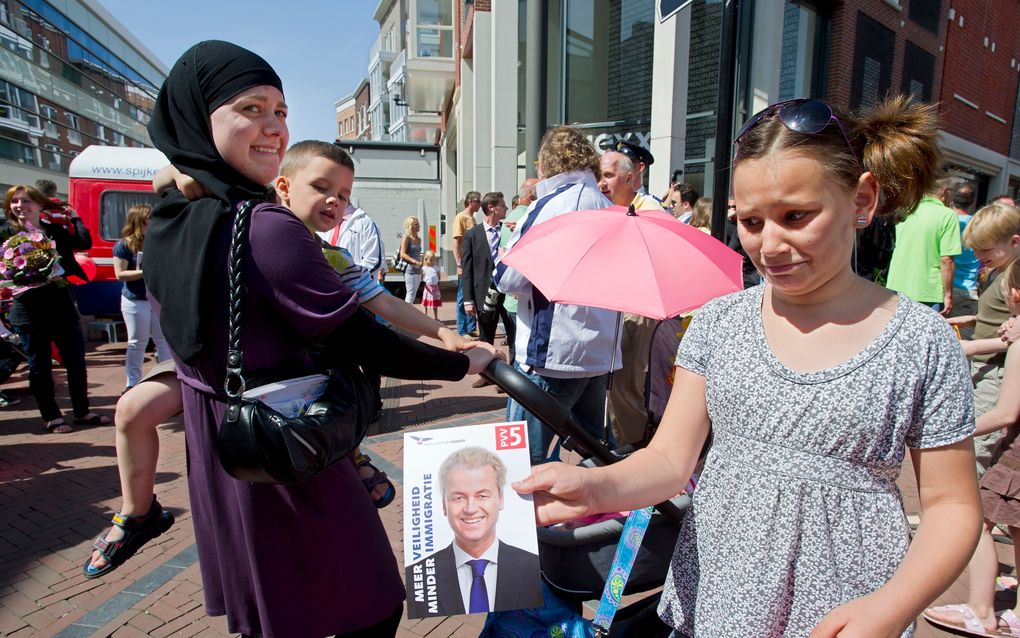 SPIJKENISSE - Een meisje staat met een folder van de PVV in haar handen tijdens het bezoek van Geert Wilders aan Spijkenisse, afgelopen zaterdag. Foto ANP