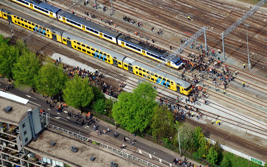 Mensen op het spoor bij Centraal Station Amsterdam, Koninginnedag 2010. Foto ANP