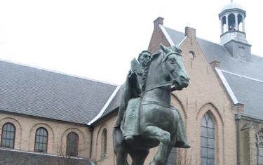 UTRECHT– Drs. Jaap van Vredendaal voor het standbeeld van Willibrord in Utrecht. De kerstening in de Lage Landen was niet alleen een politiek proces. „Het Ierse christendom, waaruit Willibrord afkomstig was, had een sterk ascetische en spirituele inslag.”