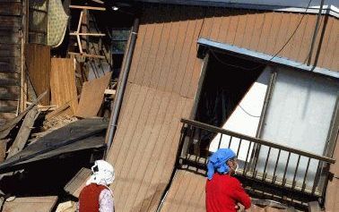 OJIYA - Een oudere vrouw bekijkt met de buurman haar ingestorte huis. Foto EPA.