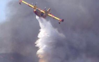 PUGET-SUR-ARGENTS - Een blusvliegtuig loost dinsdag een lading water boven een bos in het Zuid-Franse Puget-sur-Argens. Als gevolg van een hevige bos- en heidebrand in Zuid-Frankrijk zijn dinsdag duizenden mensen geÃ«vacueerd, onder meer van zes campings 