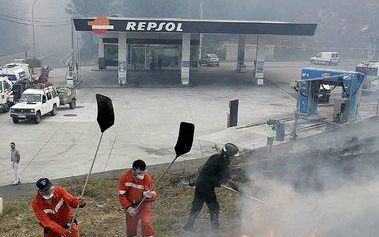 SANTIAGO DE COMPOSTELA - Brandweermannen proberen te voorkomen dat het vuur van een bosbrand overslaat naar een naastgelegen benzinestation in Santiago de Compostela. GaliciÃ« wordt geteisterd door meer dan honderd branden. Foto EPA.