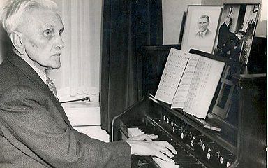 De Heer met zijn bundel voor zich achter een harmonium. Foto RD