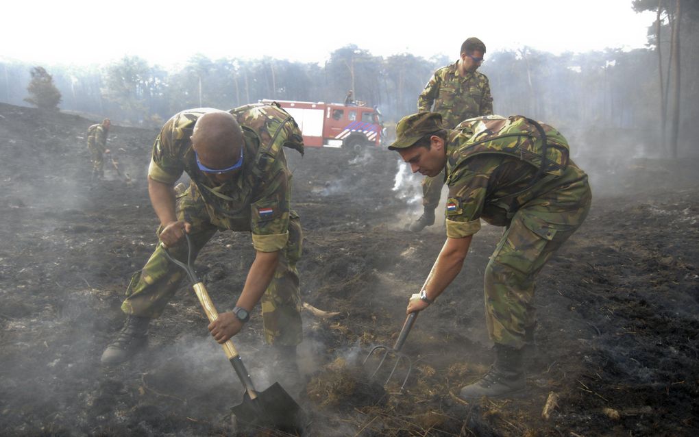 HEEZE - Militairen ondersteunen zondag de brandweer bij het nablussen van de natuurbrand op de Strabrechtse Heide bij Heeze (Noord-Brabant. Foto ANP