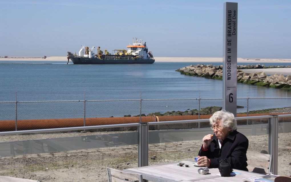 Op het terras van FutureLand geniet een bejaarde vrouw van haar kopje koffie en laat de sleephopperzuigers voor wat ze zijn. Foto Riekelt Pasterkamp