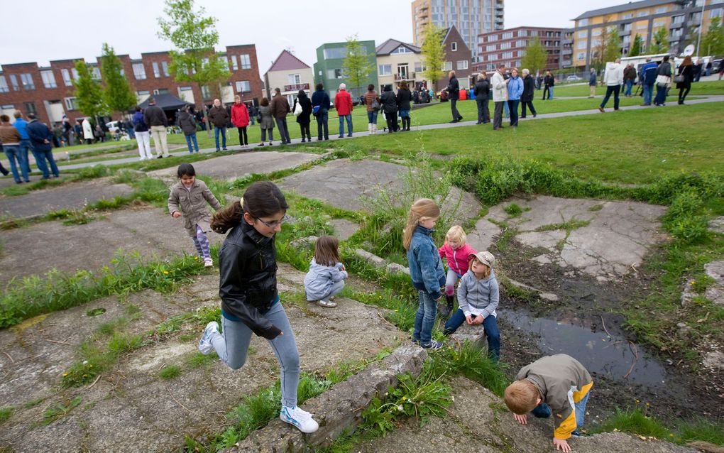 Kinderen spelen in de krater van de ontploffing, onderdeel van het monument ter nagedachtenis aan de vuurwerkramp in Enschede. Foto ANP