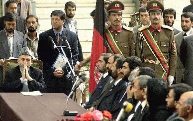 KABUL - De nieuwe Afghaanse regering is maandagmiddag formeel ingezworen. Op de foto zit president Hamid Karzai aan het hoofd van de tafel met zijn regeerploeg. - Foto EPA