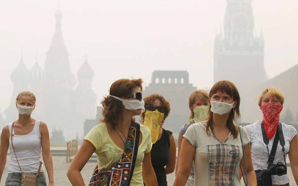 Toeristen in Moskou dragen maskers tegen de hevige smog als gevolg van de enorme bosbranden in de regio. Foto EPA