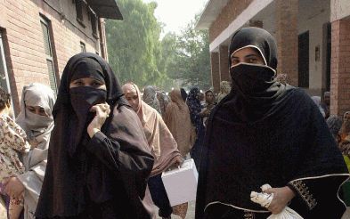 PESHAWAR - Gesluierd dragen leden van de Pakistaanse verkiezingscommissie stembussen naar de stemkantoren in de hoofdstad Peshawar. Donderdag worden er voor het eerst sinds de staatsgreep van 1999 algemene verkiezingen gehouden. - Foto EPA