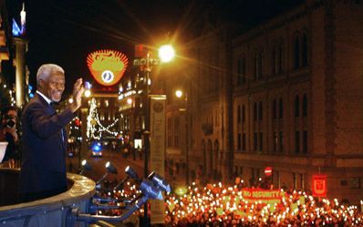 OSLO â€“ VN-secretaris-generaal Kofi Annan kijkt vanaf het balkon van zijn hotel naar de fakkelparade die in Stockholm aan hem voorbijtrekt. De fakkelparade valt traditioneel de winnaars van de Nobelprijs voor de vrede ten deel. - Foto EPA