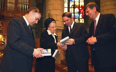 GOUDA - Drs. J. Mulder (r.), directeur van het SGP-studiecentrum, overhandigde dinsdagavond de gebundelde partijredes van ds. H. G. Abma aan diens weduwe, partijvoorzitter Kolijn (l.) en fractieleider Van der Vlies. - Foto ErikKottier