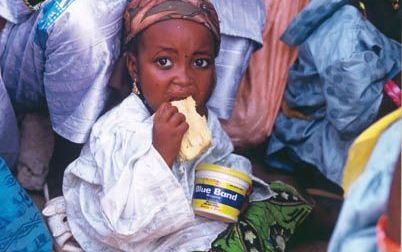 NIGERIA - Het Brits-Nederlandse voedings- en wasmiddelenconcern Unilever zag de eerstekwartaalwinst met 84 procent stijgen tot 450 miljoen euro. Op de foto een Nigeriaans meisje met een potje margarine van het merk Blue Band, een van Unilevers zogenoemde 