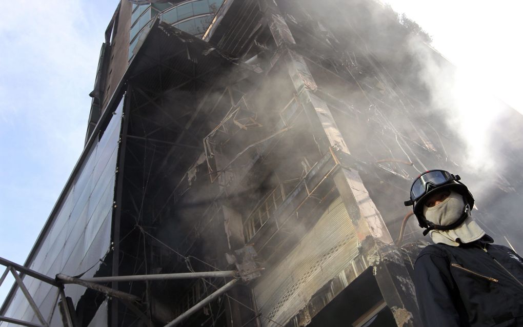 Brandweerman voor uitgebrandde winkelcentrum Bangkok. Foto EPA